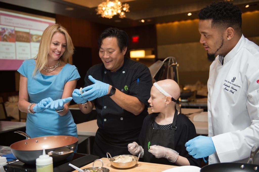 Chef Ming Tsai, second from left, cooks with Carla Tardif, CEO of Family Reach, left, New England Patriots safety Patrick Chung and Ashlynn Hull, 11, during the Family Reach fundraising event, "Cooking Live! Boston" in Boston, Tuesday, May 3, 2016. Family Reach provides financial support to families battling cancer nationwide. (Gretchen Ertl/AP Images for Family Reach)