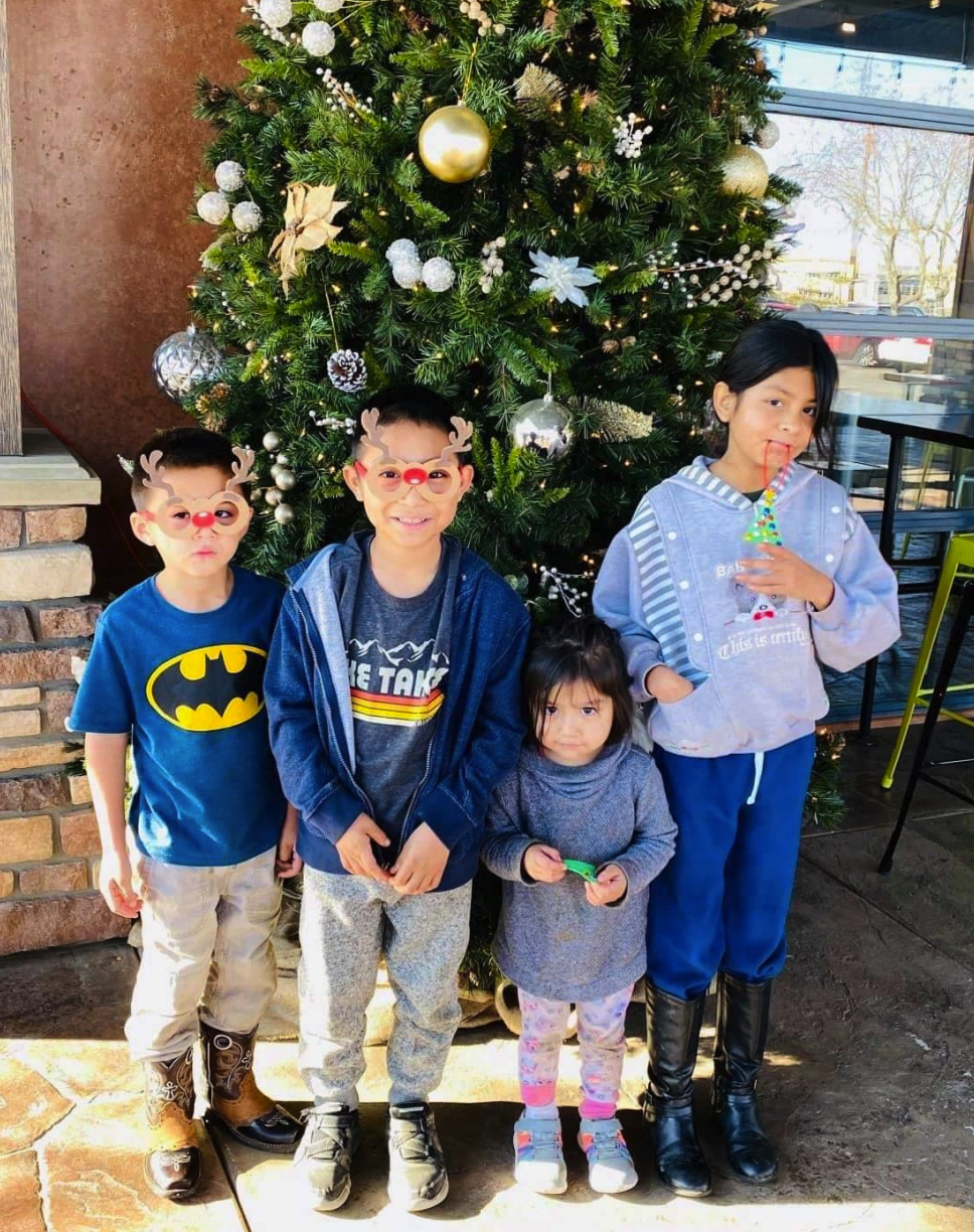 Cancer hero Ruben with his siblings in front of a Christmas tree