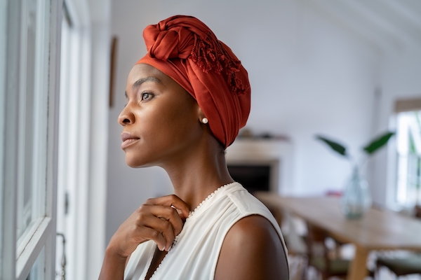 Woman with headscarf looking out window