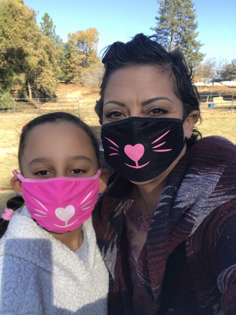 Cancer survivor Renee wearing cat face masks with her daughter