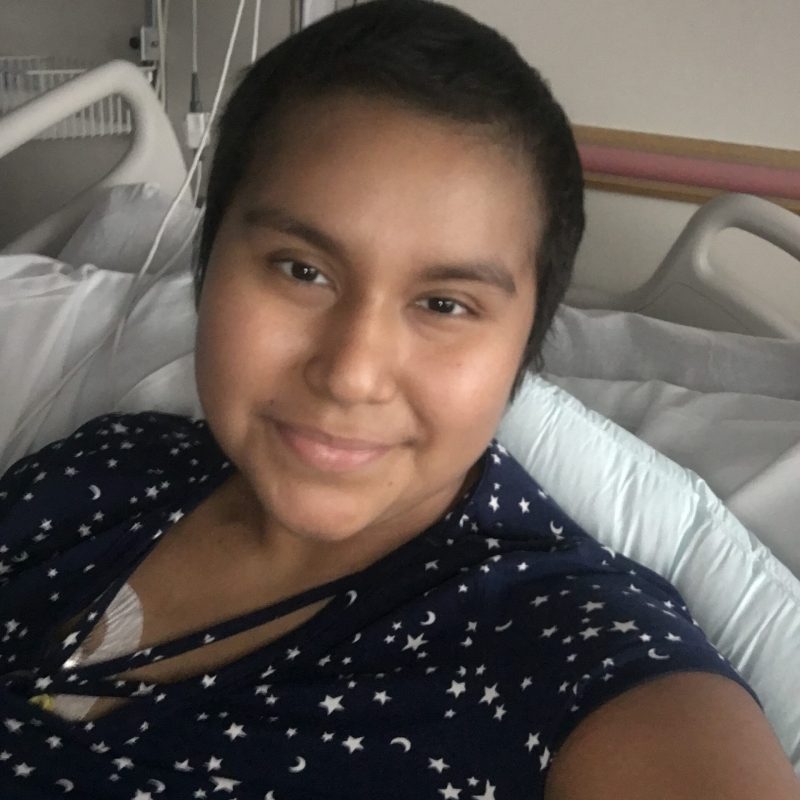 Cancer hero Vanessa smiling in hospital bed